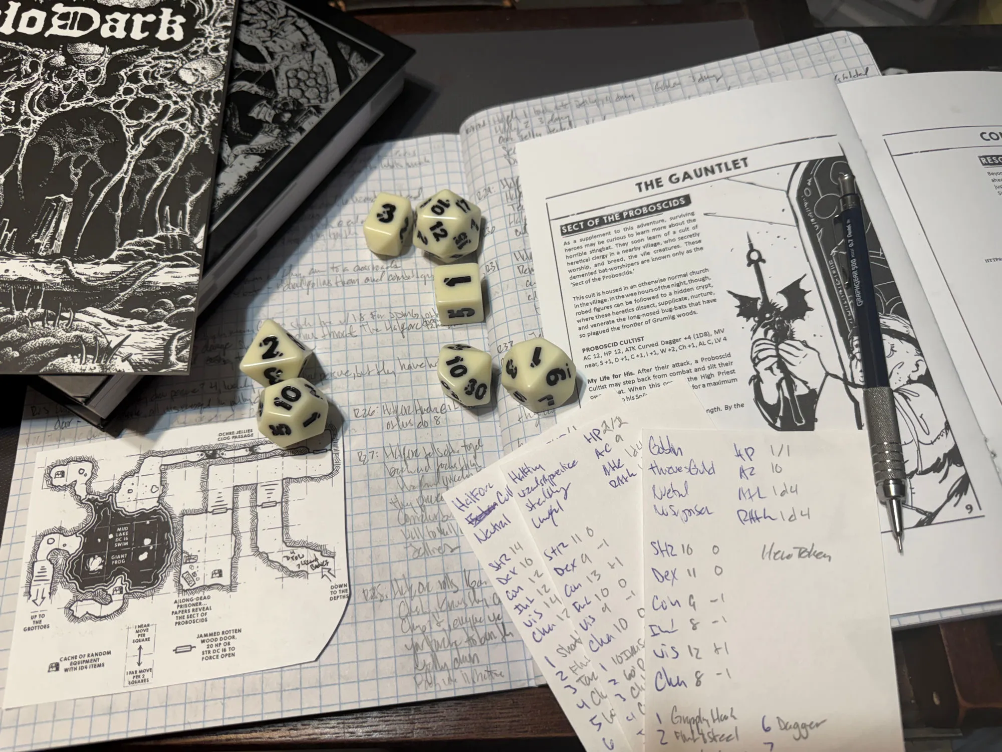 Shadowdark rulebook, glow-in-the-dark dice, the Cry of the Stingbat gauntlet map and Sect of the Proboscis page, and handwritten character sheets on graph paper